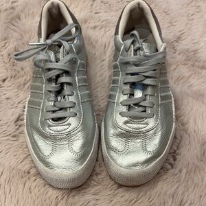 Silver metallic adidas Samba sneakers.